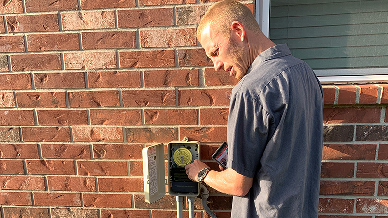 technician turning on an Intermatic time clock