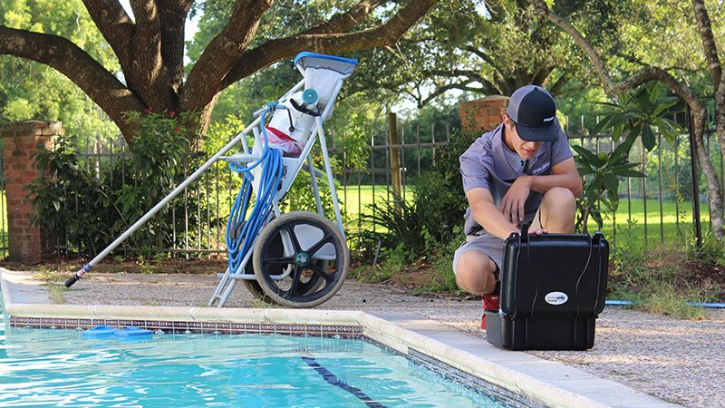 The Pool Boys maintenance technician Drew testing a customer's pool water